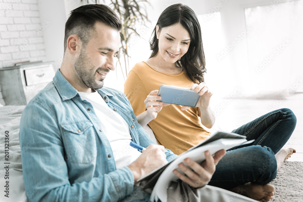Educational material. Happy joyful two students sitting while woman taking photo and using smartphone Educational material. Happy joyful two students sitting while woman taking photo and using smartphone