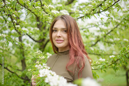 lovely girl in spring blossoming garden