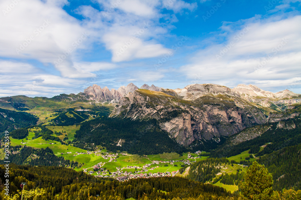 view the green valley from the pine forest of the rocky mountains of the dolomites italy, south tyrol, in summer time, wide angle