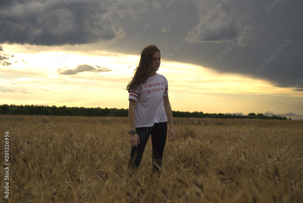 chica joven, mujer, posando en medio de un campo de trigo al atardecer chica joven, mujer, posando en medio de un campo de trigo al atardecer