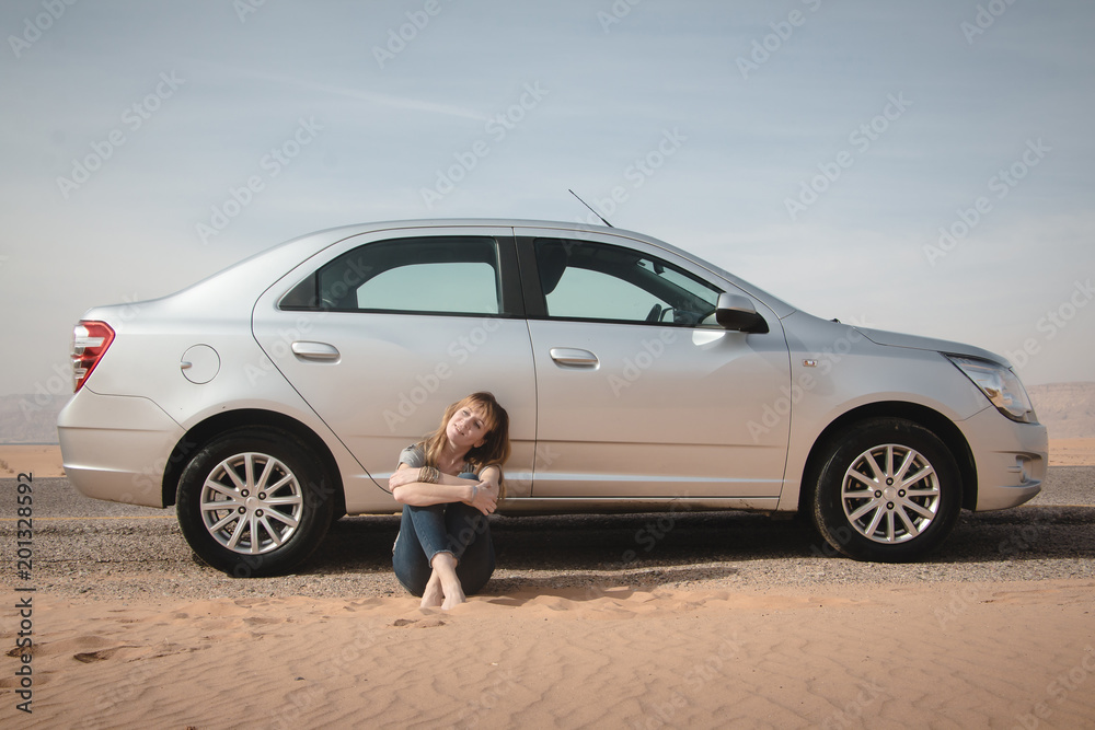 Girl have rest near car in desert