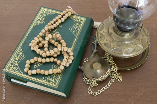 Koran,rosary and oil lamp on the wooden ground..Holy book for Muslims for Ramadan concept.