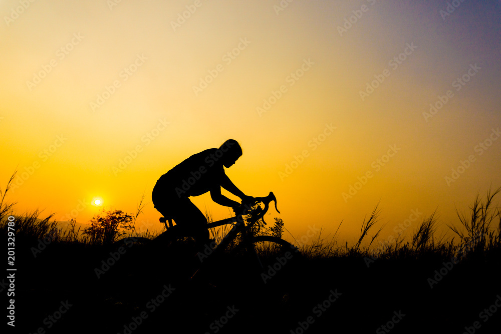 Silhouette of cyclist with friend in motion on the background of beautiful sunset Silhouette of cyclist with friend in motion on the background of beautiful sunset