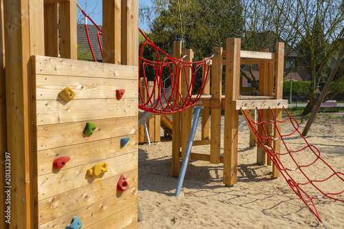 Sand with various wooden playground equipment on a public playground in Berlin