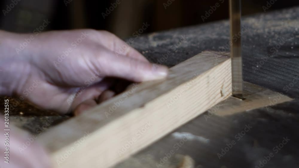 carpenter detail cuts a piece of wood with a band saw
