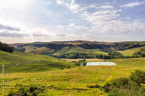 Typical Tuscan Landscape, Gentle Hills, Sheepand Small Lake Under A Summer Sky