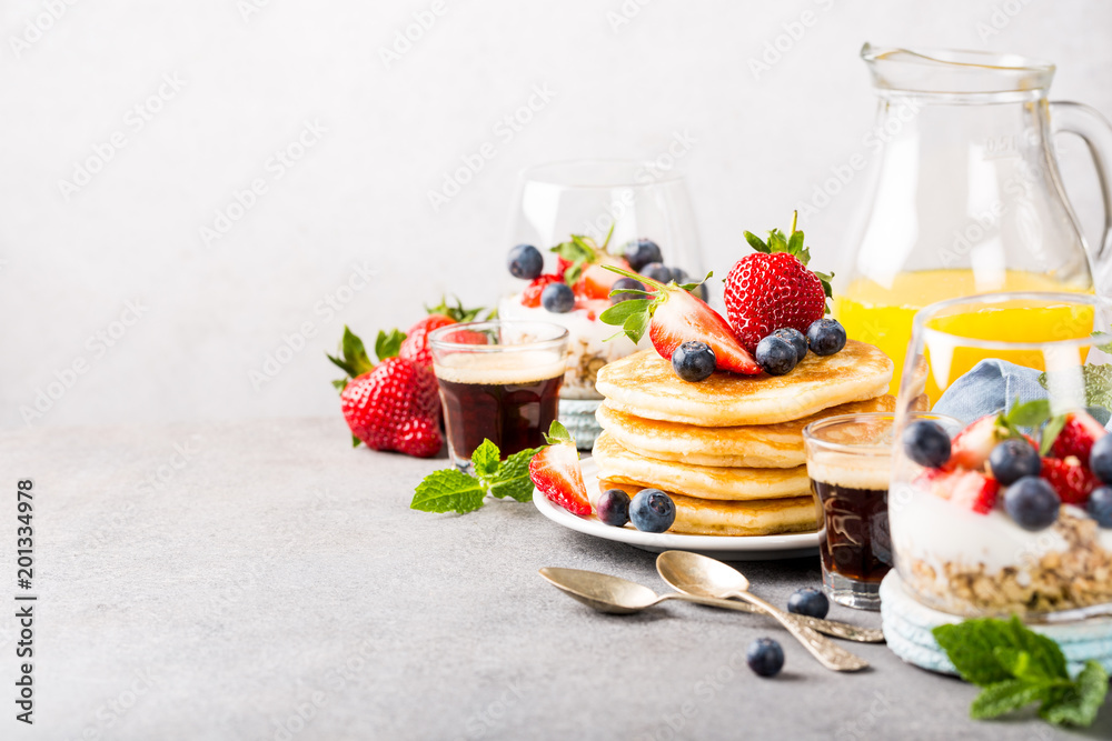 Breakfast background with fresh pancakes and berries on light gray concrete table. Healthy food concept with copy space. - obrazy, fototapety, plakaty 