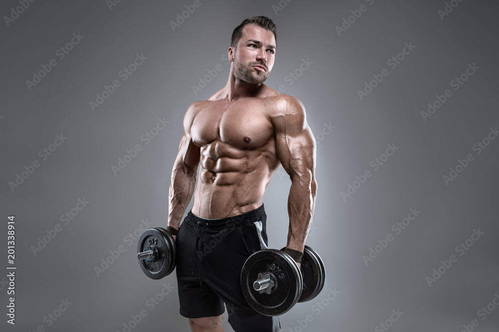 Muscular bodybuilder guy doing exercises with dumbbell Muscular bodybuilder guy doing exercises with dumbbell