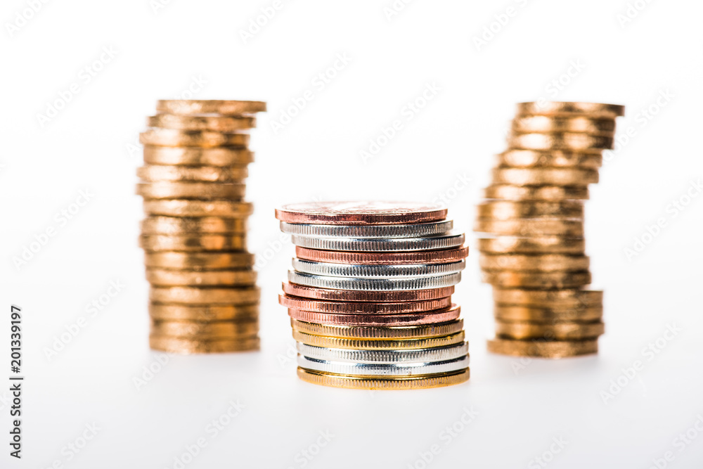 close-up view of various stacked shiny coins isolated on white close-up view of various stacked shiny coins isolated on white
