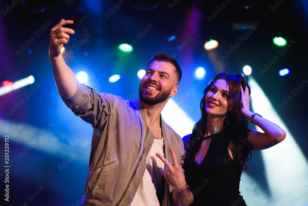 Image of happy young couple having fun at disco. Young man and woman enjoying a party. Image of happy young couple having fun at disco. Young man and woman enjoying a party.