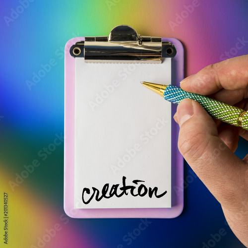 Writing pad with hand and pen poised to draw, write, sketch and be creative, isolated and presented on a trendy colourful background, for creative design, web and print