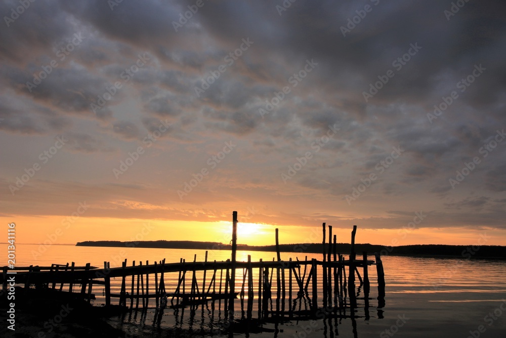 silhouette of a wooden jetty at sunset, vacation by the sea