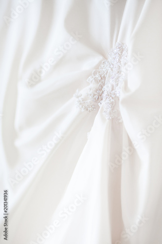 Fototapeta Naklejka Na Ścianę i Meble -  Bride's dress with embroidered elements and beads. Bridal traditional symbolic accessory for wedding ceremony.