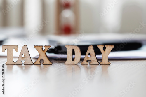 Word TAX DAY composed of wooden letters. Closeup photo