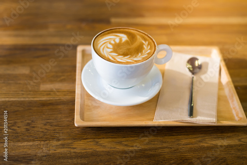 A Cup of hot latte art coffee on wooden table