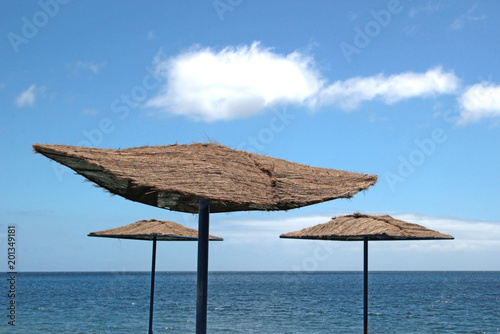 parasols with palm tree mesh at a beach of a canary island