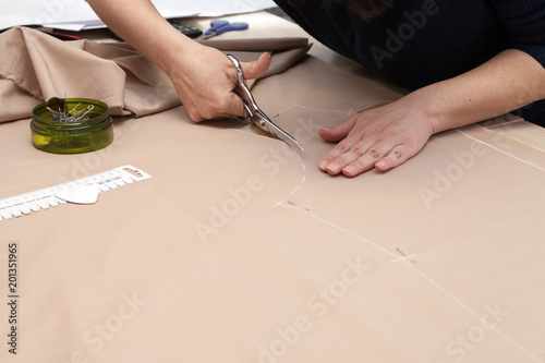 Женщина выкраивает одежду.