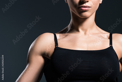 cropped view of muscular sportswoman,  isolated on grey
