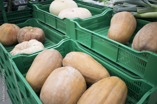 Bunch of new harvest pumpkins on boxes in supermarket photo