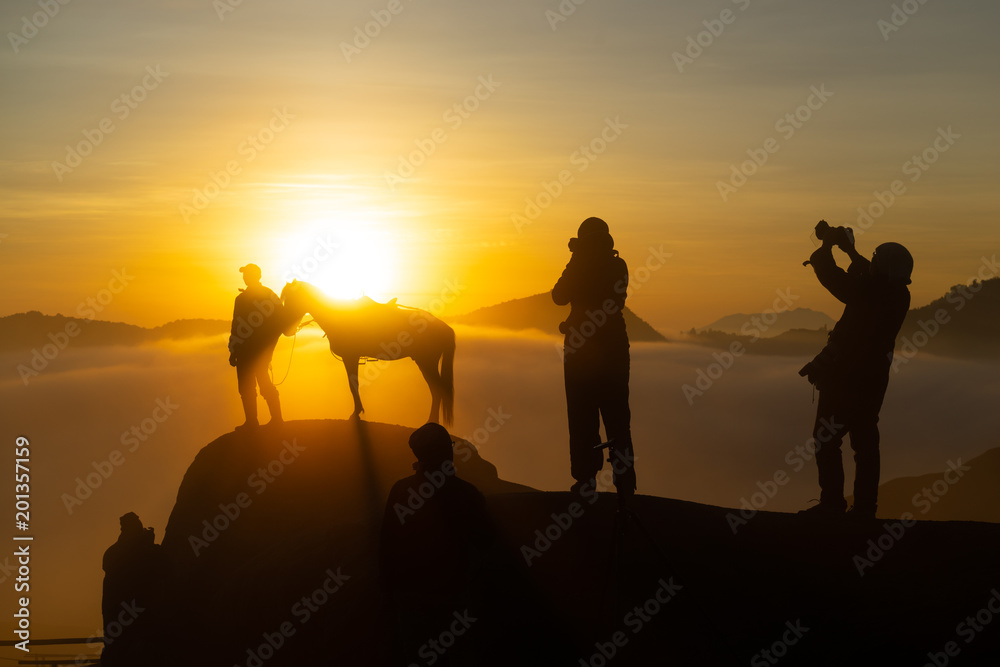 Silhouette of unidentified local people or Bromo Horseman pose for camera at the mountainside of Mount Bromo, Semeru, Tengger National Park, Indonesia.