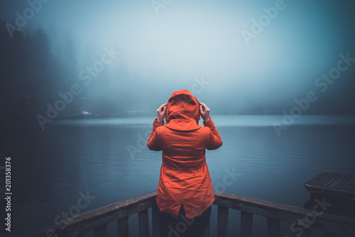 The girl looks at a mountain lake photo