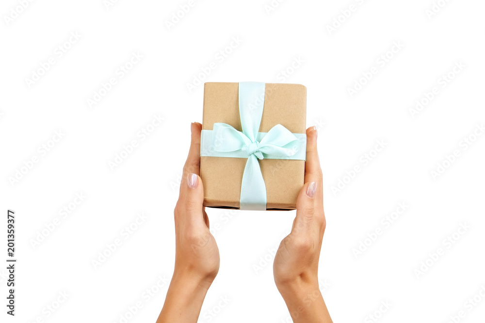 Close up of female hands holding birthday gift in vintage craft paper wrapping. Femenine composition with present in woman's arms. Close up of female hands holding birthday gift in vintage craft paper wrapping. Femenine composition with present in woman's arms.