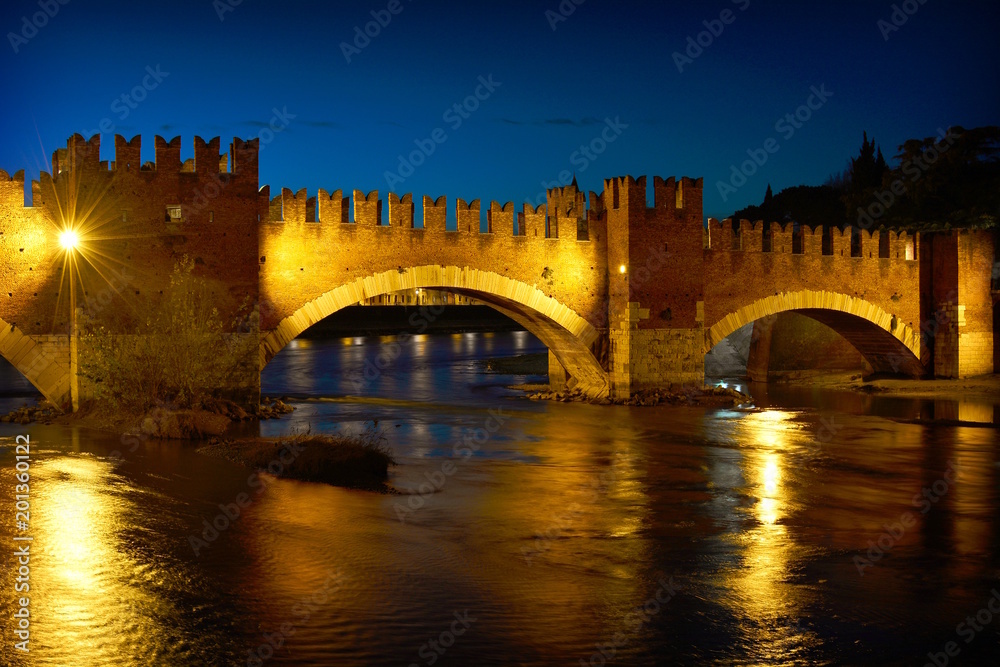The medieval bridge in Verona on the river by night, Italy.