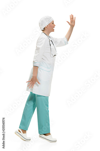 Beautiful young woman in white coat posing at studio. Full length studio shot isolated on white.