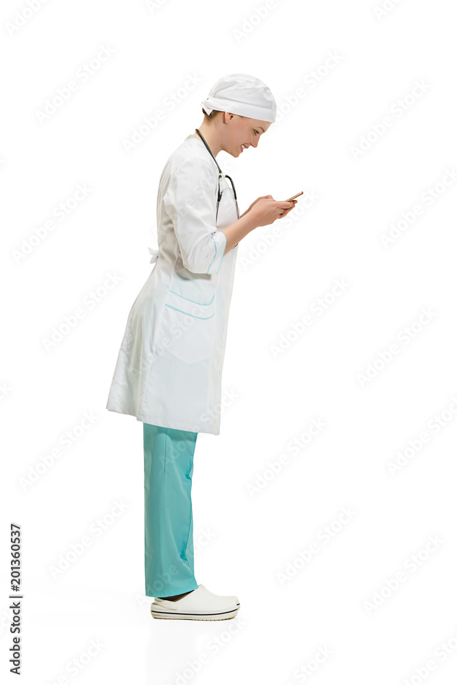 Beautiful young woman in white coat posing at studio. Full length studio shot isolated on white. Beautiful young woman in white coat posing at studio. Full length studio shot isolated on white.