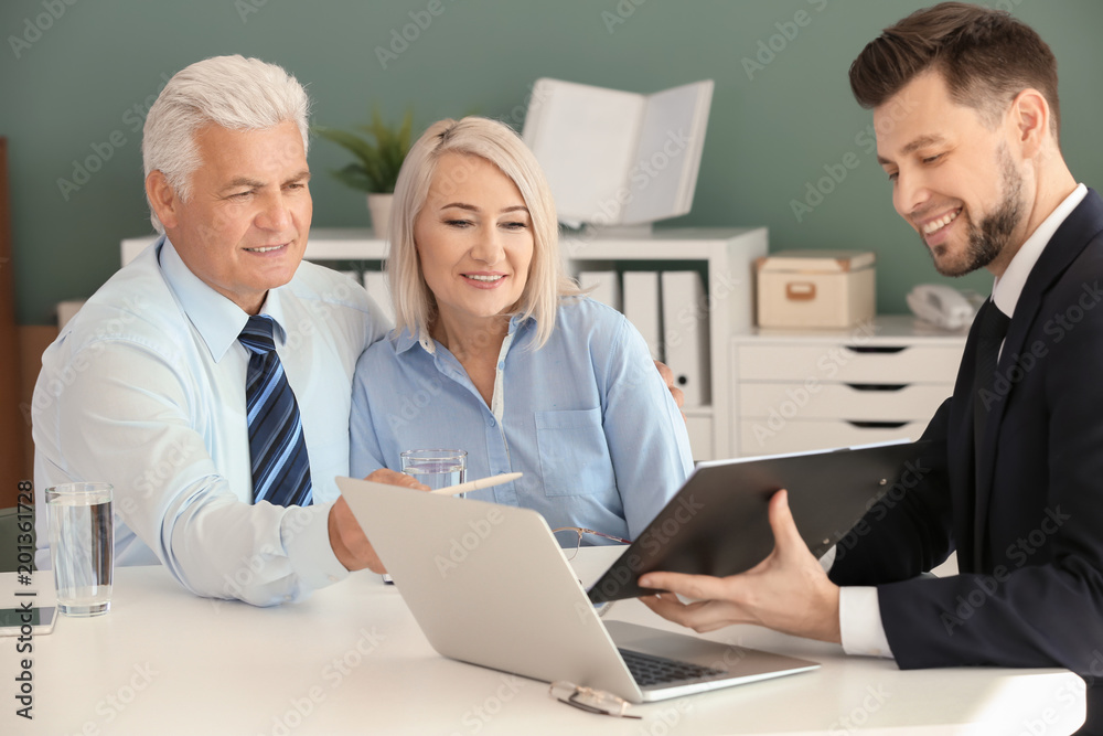 Male manager consulting mature couple in office Male manager consulting mature couple in office