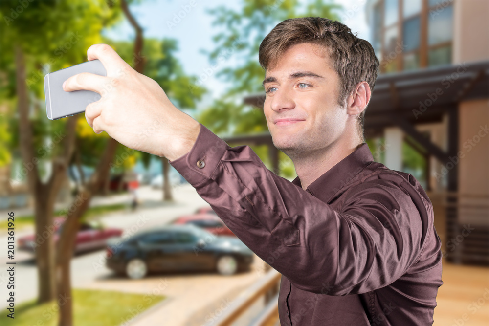 Young man taking selfie with his smartphone. Close up shot Young man taking selfie with his smartphone. Close up shot