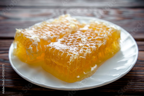 honey in honeycombs on a white plate 