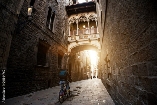 Barcelona people biking bicycle in Barri Gothic Quarter and Bridge of Sighs in Barcelona, Catalonia, Spain..