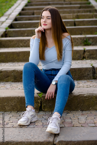 Young girl portrait sitting on stairs in park 