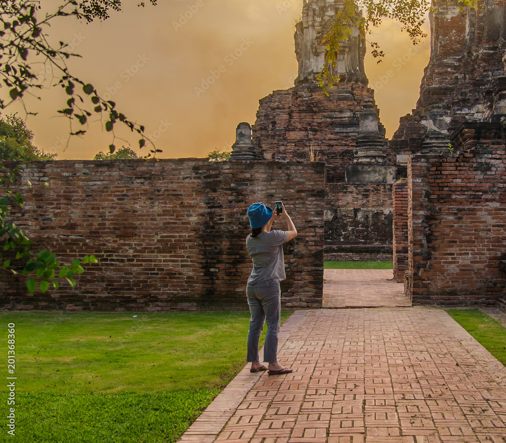 Beautiful women photographed with mobile phones in the morning, relax and rest in Ayutthaya.