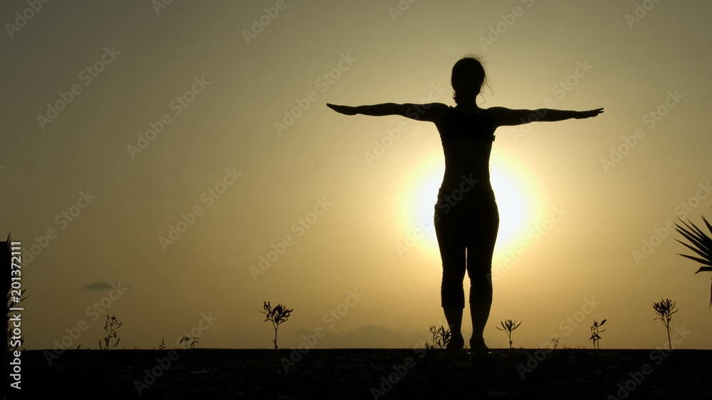 Female silhouette doing yoga exercises for harmony of healthy body and mind