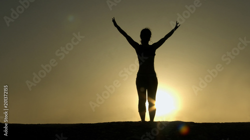 Female silhouette greeting sun, successful goal achievement, strength of spirit