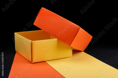 Opened homemade paper gift box on dark background.