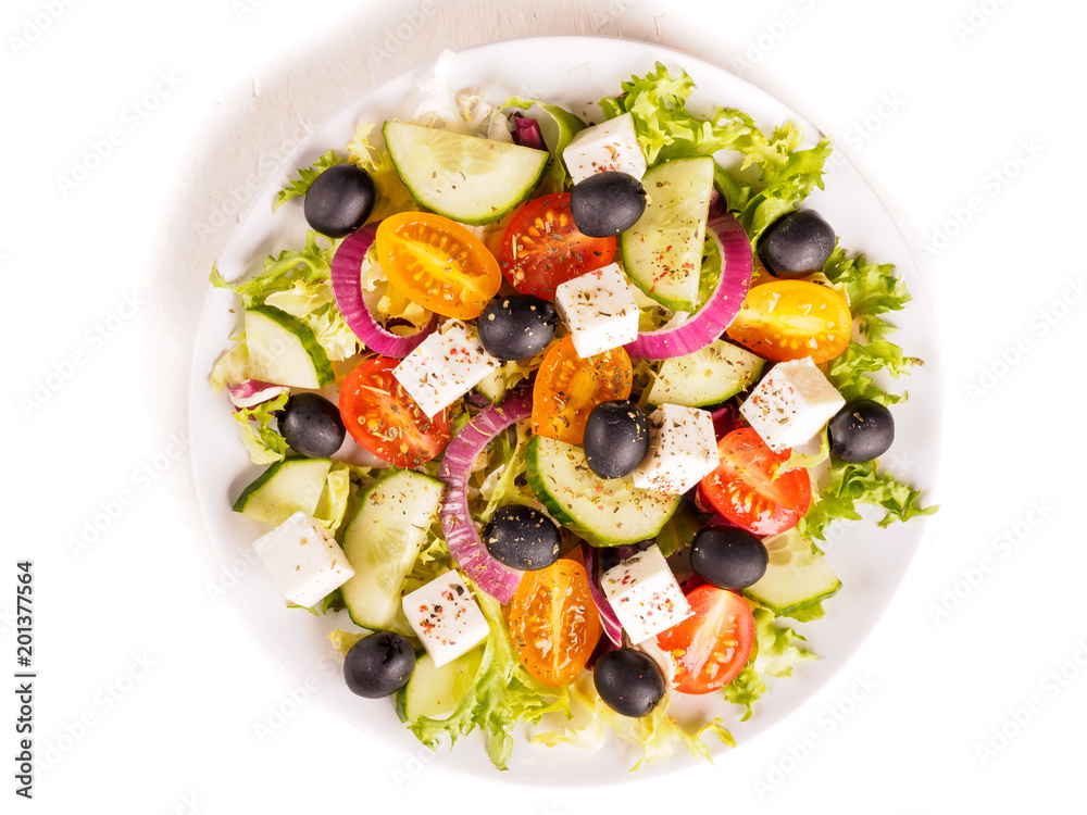 Greek salad with feta cheese, olive, tomatoes, cucumbers, peppers and oil olives in white plate. Restaurant menu. Free space for text. Isolated on white background Greek salad with feta cheese, olive, tomatoes, cucumbers, peppers and oil olives in white plate. Restaurant menu. Free space for text. Isolated on white background