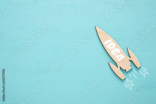 Top view of wooden rocket with word - idea - over blue background. © tomertu