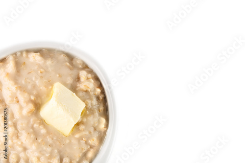 breakfast: oatmeal porridge with butter in white bowl on white background. Top view. Isolated