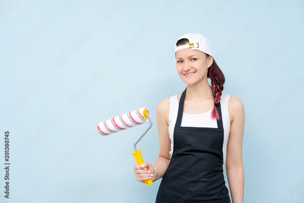 Girl painter, designer and worker paints a roller and brush the wall. Girl painter, designer and worker paints a roller and brush the wall.