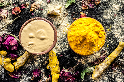 Ayurvedic ubtan of Haldi with holy rose water and fuller’s earth on wooden surface for good, brighter, and softer skin. photo