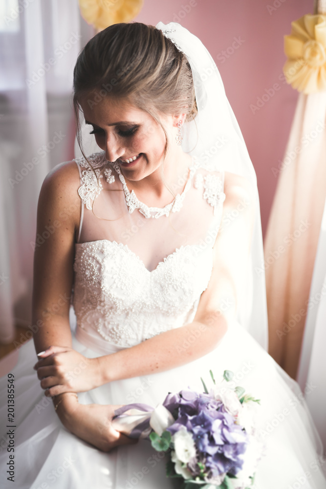 Naklejka premium Gorgeous bride in robe posing and preparing for the wedding ceremony face in a room