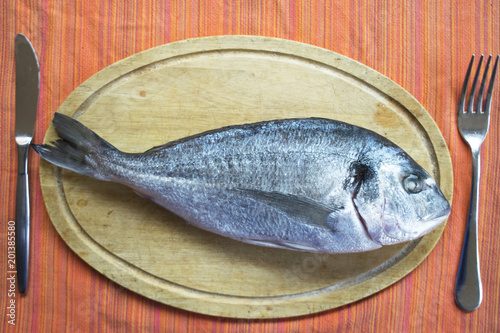 gilthead sea bream fish on a wooden dish photo