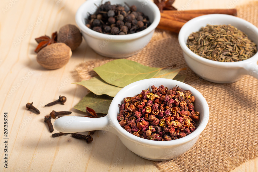 Exotic spices concept Chinese Asian Spices mix Sichuan peppercorns, star anise pods, bay leave, black peppers, nutmegs, cloves and cinnamon sticks with copy space Exotic spices concept Chinese Asian Spices mix Sichuan peppercorns, star anise pods, bay leave, black peppers, nutmegs, cloves and cinnamon sticks with copy space