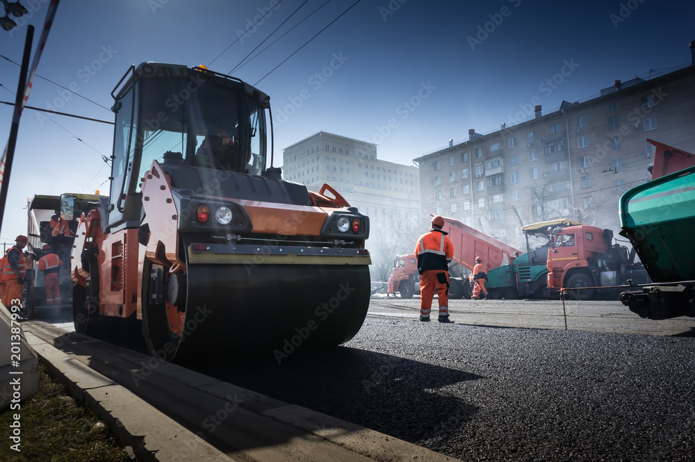 road repairing in urban modern city with heavy vibration roller compactor and asphalt spreader and dump truck