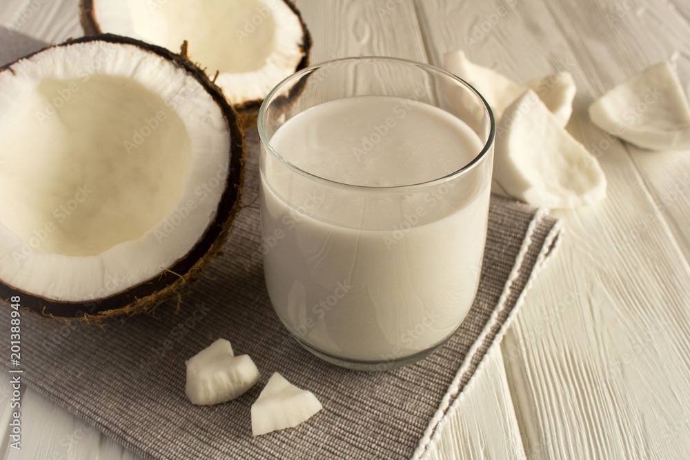 Coconut milk in the glass on the grey napkin Coconut milk in the glass on the grey napkin