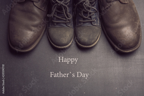 Daddy's boots and baby's shoes, fathers day concept.