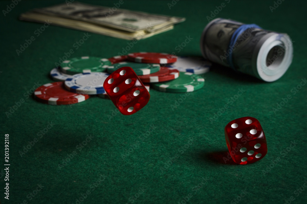 Dice on the poker table against the background of poker chips and dollars Dice on the poker table against the background of poker chips and dollars